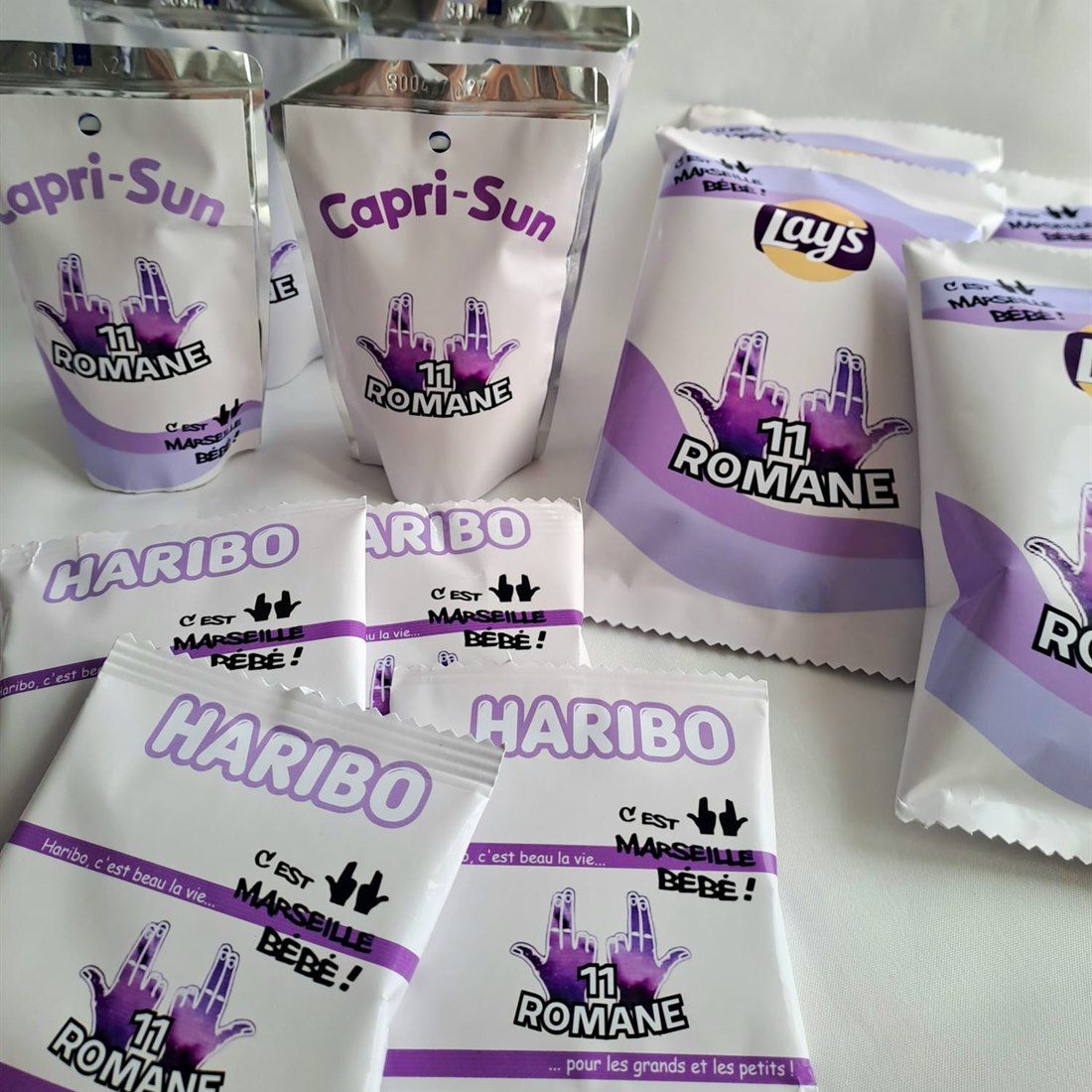Gourdes, chips et bonbons habillés d'étiquettes personnalisées violettes sur le thème du chanteur Jul.